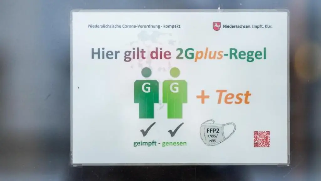 Ein-Schild-Hier-gilt-die-2Gplus-Regel-haengt-an-einer-Tuer