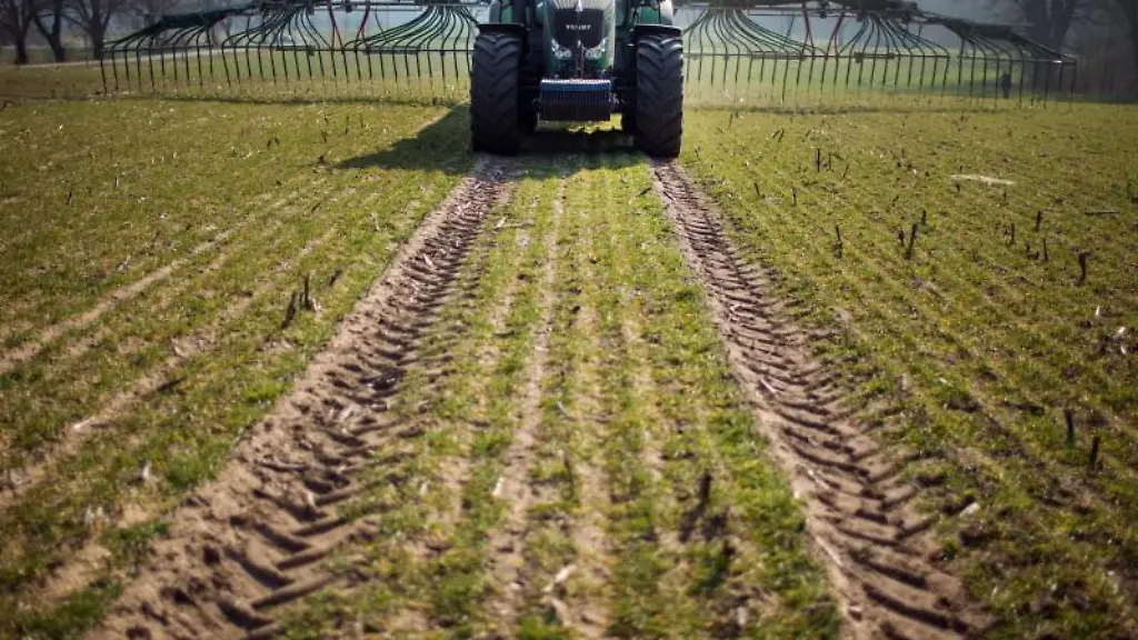Mit-einem-Guellewagen-wird-auf-einem-Acker-organischer-Duenger-ausgebracht