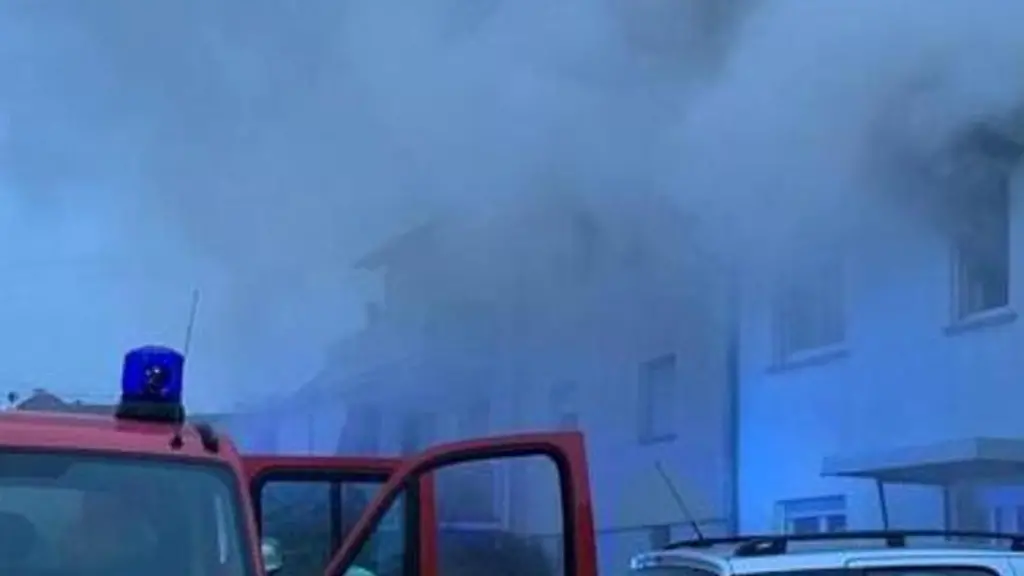 Einsatzkraefte-der-Feuerwehr-loeschen-einen-Brand-in-einem-Wohnhaus-Foto