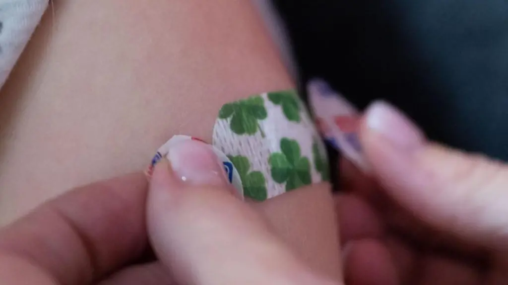 Eine-Impfaerztin-klebt-ein-Pflaster-auf-den-Oberarm-eines-Kindes