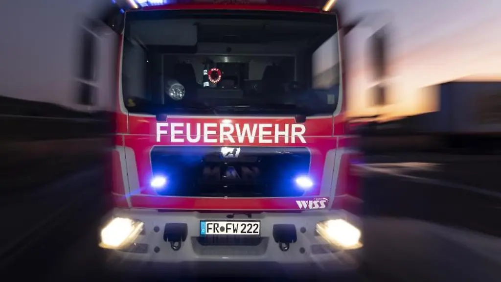 Ein-Feuerwehrfahrzeug-steht-mit-eingeschaltetem-Blaulicht-auf-einer-Strasse
