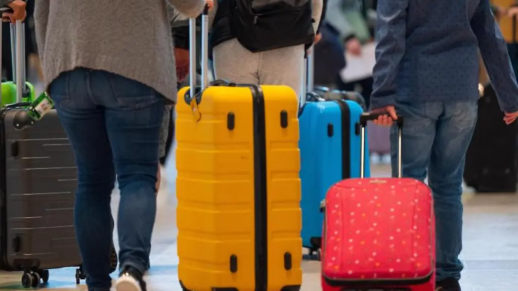 Fluggaeste-schieben-ihre-Rollkoffer-durch-den-Abflugbereich-im-Terminal-1-des-Flughafens-BER