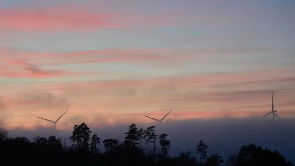 Windraeder-ragen-am-Abend-bei-Pfazfeld-im-Hunsrueck-aus-dem-Bodennebel