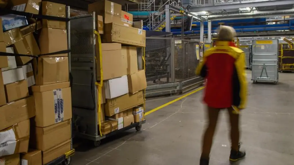 Pakete-stapeln-sich-auf-zwei-Befoerderungswagen-im-Paketzentrum-der-Post