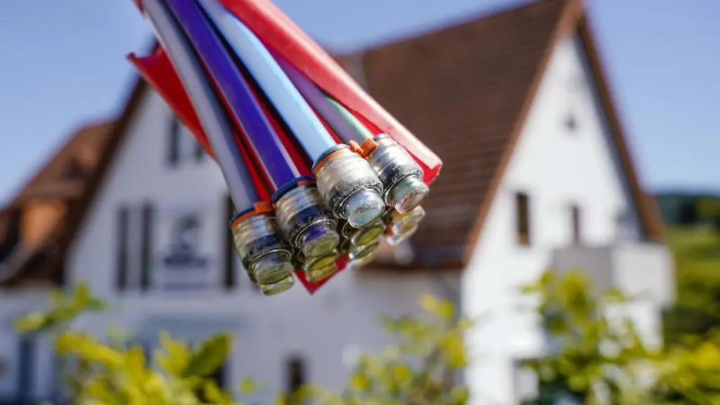 Ein-Buendel-mit-Umhuellungen-fuer-Glasfaserkabel-haengt-vor-einem-Wohnhaus