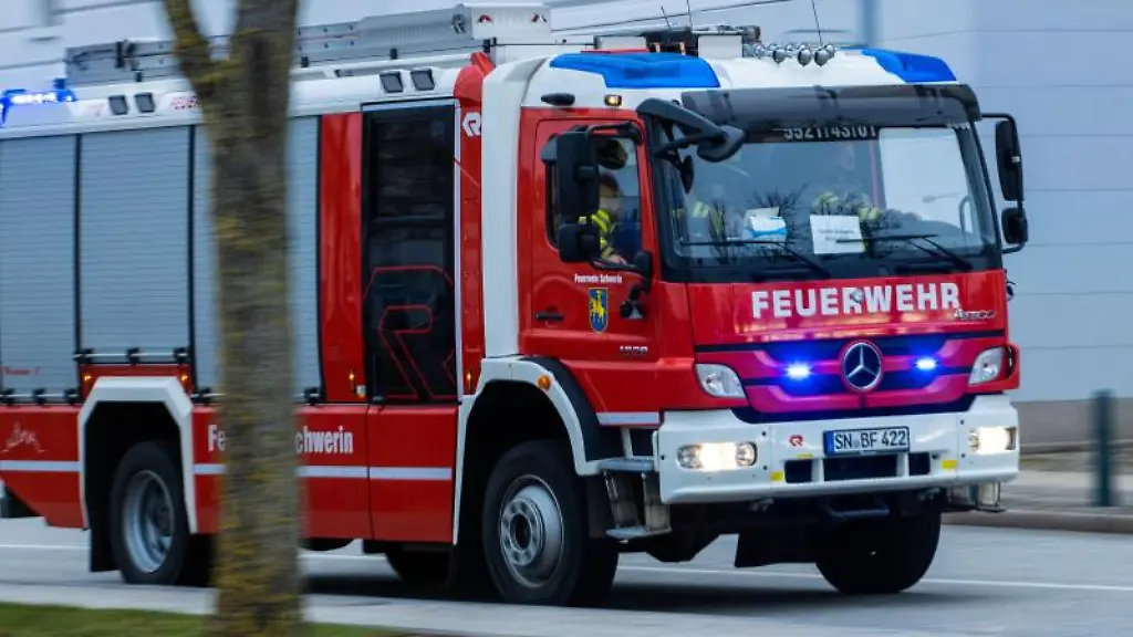 Ein-Feuerwehrfahrzeug-faehrt-mit-Blaulicht-zu-einem-Einsatz