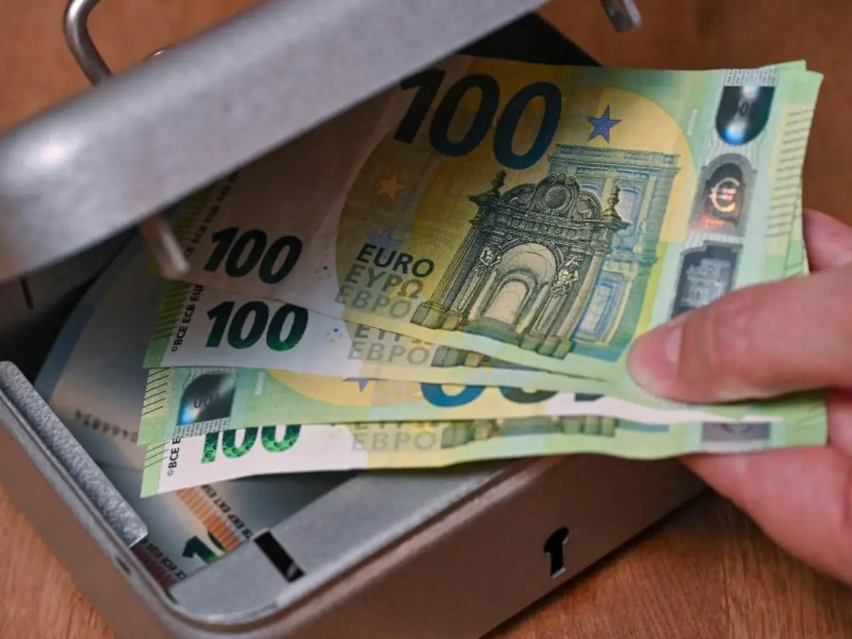 Eine-Frau-holt-Eurobanknoten-aus-einer-kleinen-Geldkassette