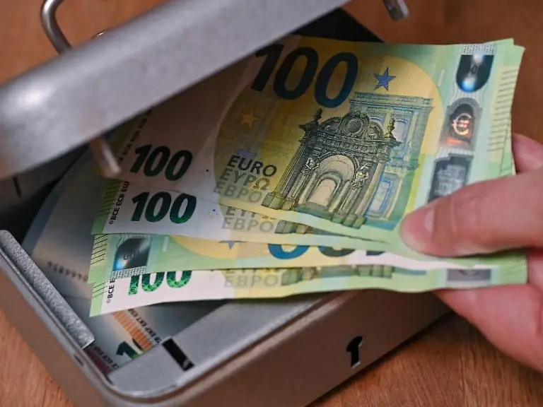 Eine-Frau-holt-Eurobanknoten-aus-einer-kleinen-Geldkassette