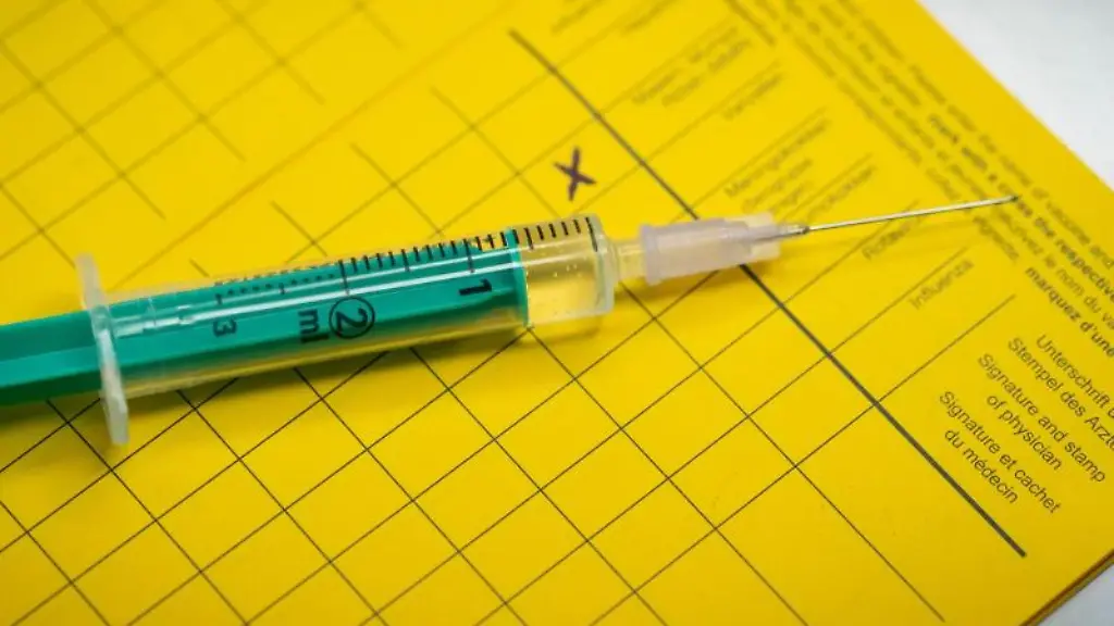 Eine-Spritze-liegt-auf-einem-Impfpass