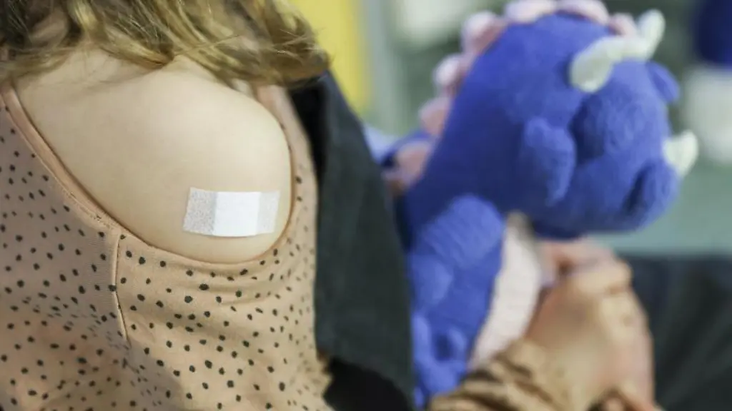 Ein-Pflaster-klebt-auf-den-Arm-eines-Maedchens-nachdem-es-gegen-das-Covid-19-Virus-geimpft-wurde