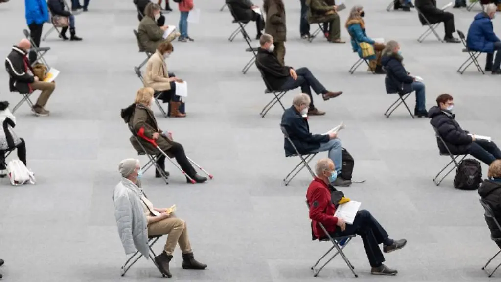 Menschen-sitzen-am-ersten-Tag-des-Impfmarathons-in-der-August-Schaerttner-Halle-in-Hanau