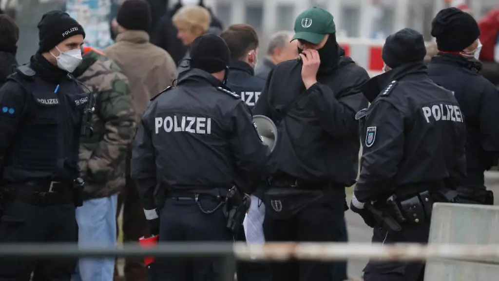 Anhaenger-der-rechtsextremen-Vereinigung-Neue-Staerke-halten-umgeben-von-Polizisten-eine-Kundgebung-ab