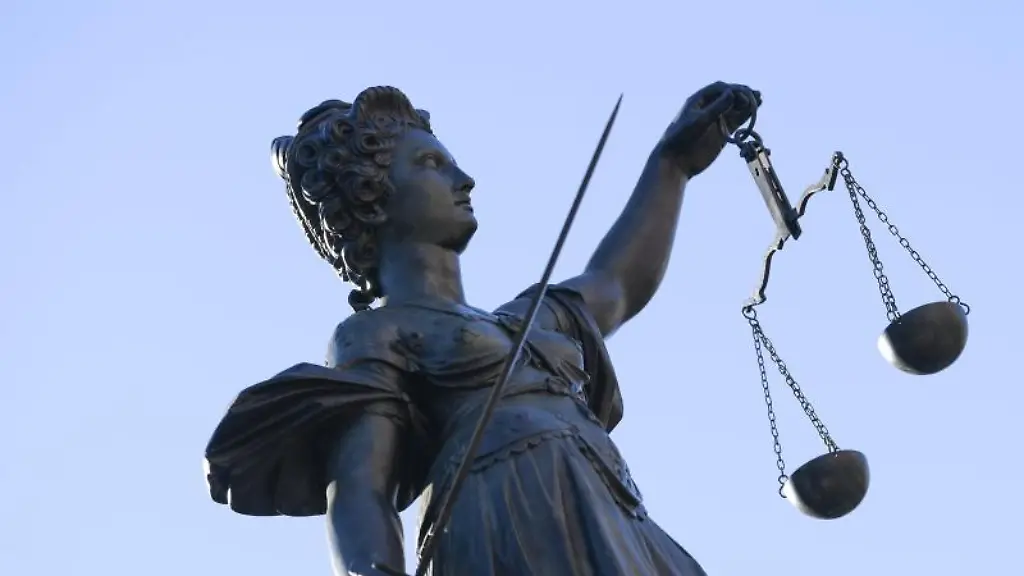 Eine-Statue-der-Justitia-steht-unter-freiem-Himmel