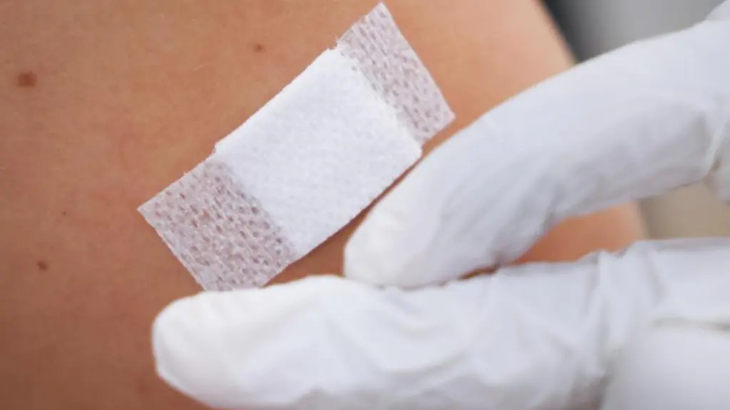 Eine-Aerztin-klebt-nach-einer-Corona-Impfung-ein-Pflaster-auf-den-Arm-eines-Impflings