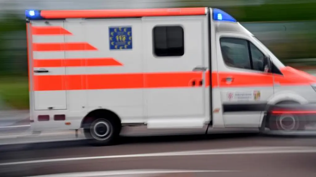 Ein-Krankenwagen-faehrt-mit-Blaulicht-auf-einer-Strasse