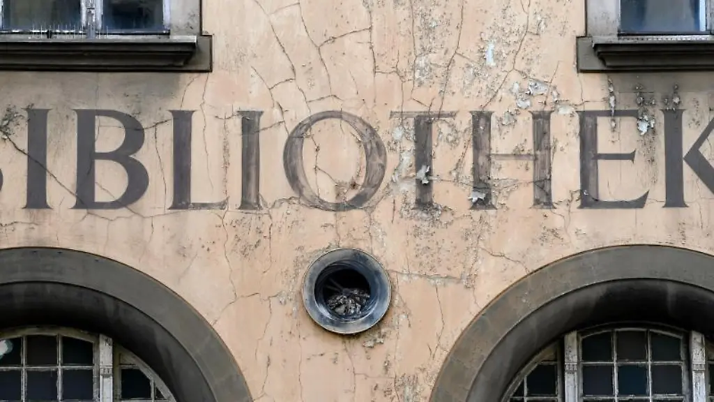 Der-Schriftzug-Bibliothek-blaettert-von-einer-Fassade