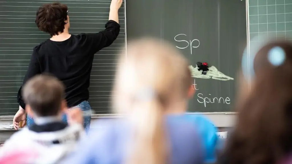 Eine-Lehrerin-schreibt-in-einer-Schule-an-die-Tafel
