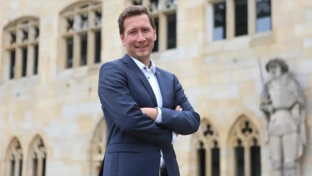 Daniel-Szarata-CDU-steht-vor-dem-Rathaus-fuer-ein-Foto