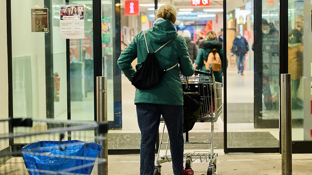 Eine-Frau-schiebt-den-Einkaufswagen-in-einen-Supermarkt