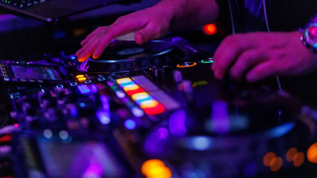 Die-Haende-eines-DJ-bedienen-ein-Mischpult-in-einem-Club