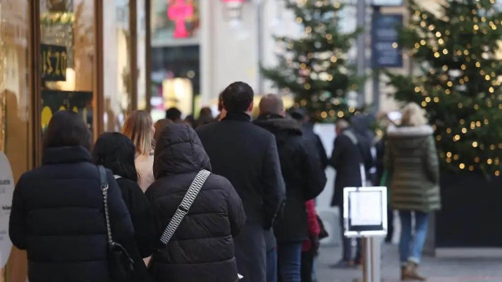 Menschen-stehen-an-der-2G-Kontrolle-am-Eingang-zu-einem-Geschaeft-in-der-Schlange