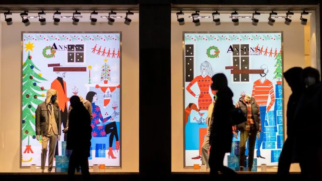 Passantinnen-gehen-an-weihnachtlich-geschmueckten-Schaufenstern-in-der-Nuernberger-Innenstadt-vorbei