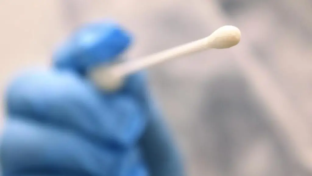 Ein-Arzt-haelt-einen-Tupfer-mit-dem-ein-Abstrich-fuer-einen-Coronatest-gemacht-wird