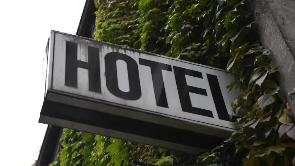 Ein-Leuchtschild-haengt-an-der-Fassade-eines-Hotels