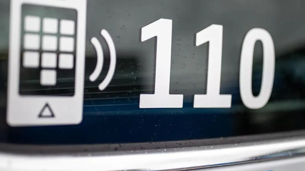 Der-Nummer-des-Polizeinotrufs-110-steht-auf-der-Scheibe-eines-Polizeifahrzeugs