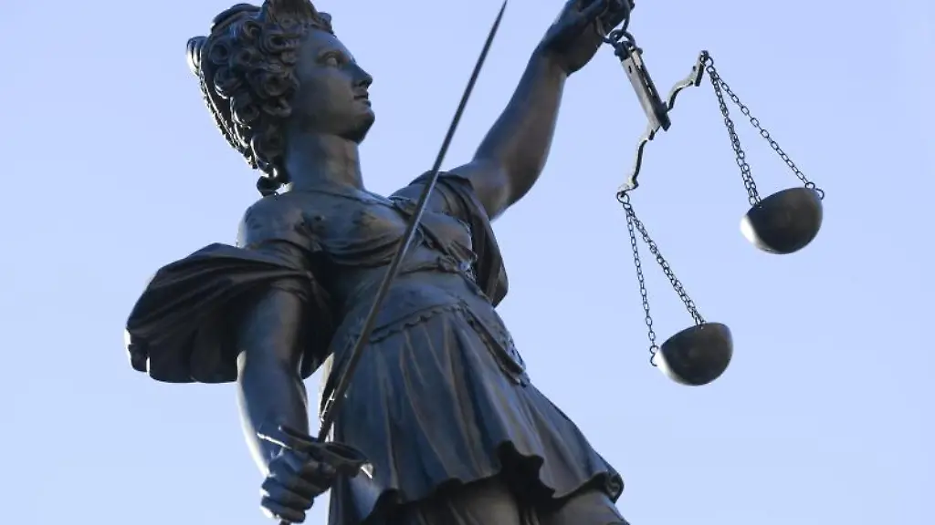 Eine-Statue-der-Justitia-steht-unter-freiem-Himmel