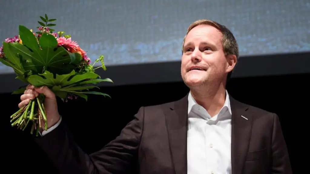 Oke-Goettlich-haelt-nach-seiner-Wahl-zum-Praesidenten-einen-Blumenstrauss