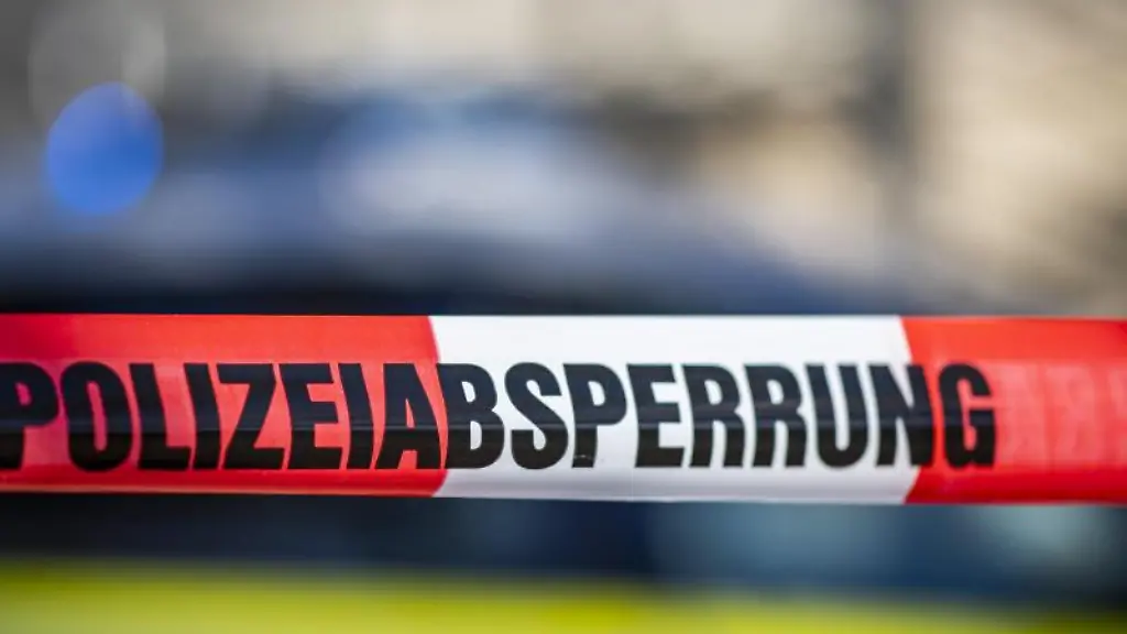 Ein-Absperrband-ist-vor-einem-Polizeiwagen-aufgespannt