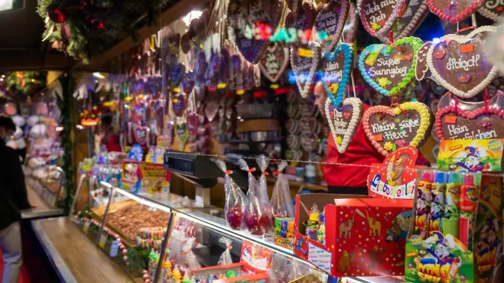 Ein-Stand-auf-einem-Weihnachtsmarkt-bietet-Suessigkeiten-wie-Lebkuchenherzen-zum-Verkauf-an