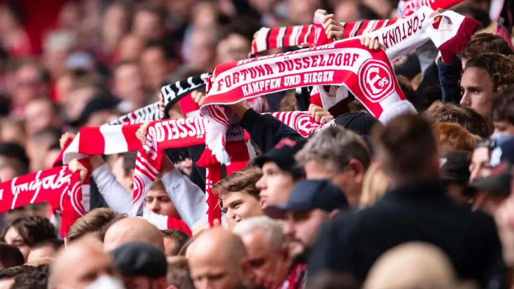 Duesseldorfer-Fans-halten-vor-einer-Partie-ihre-Fanschals-in-die-Hoehe