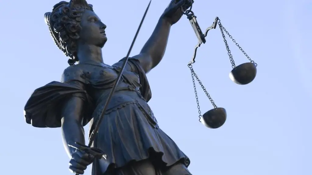 Eine-Statue-der-Justitia-steht-unter-freiem-Himmel