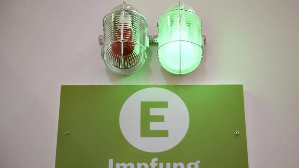 Eine-gruene-Lampe-leuchtet-am-Eingang-eines-Corona-Impfzentrums