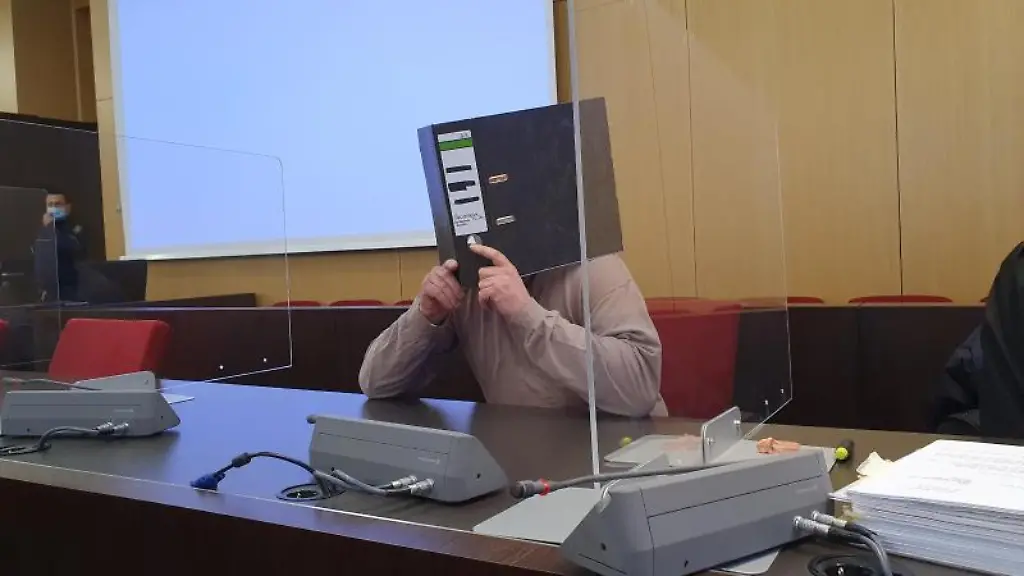 Der-40-Jaehrige-Angeklagte-verbirgt-im-Duesseldorfer-Landgericht-sein-Gesicht-hinter-einem-Aktenordner