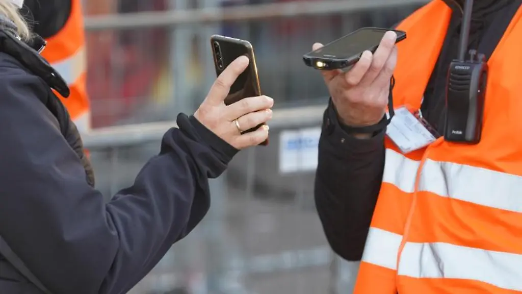 Eine-Frau-zeigt-ihen-Impfnachweis-beim-Eingang-zum-Weihnachtsmarkt