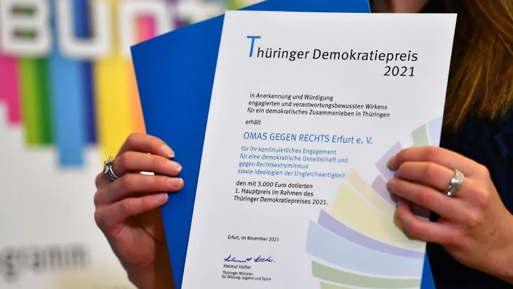 Eine-Frau-praesentiert-die-Urkunde-fuer-den-1-Hauptpreis-fuer-die-Omas-gegen-Rechts-Erfurt-e-V
