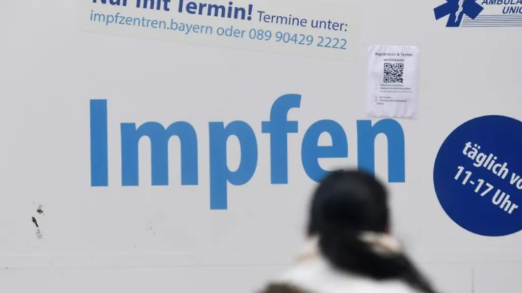 Eine-Frau-steht-vor-einem-Impfzentrum-im-Muenchner-Rathaus