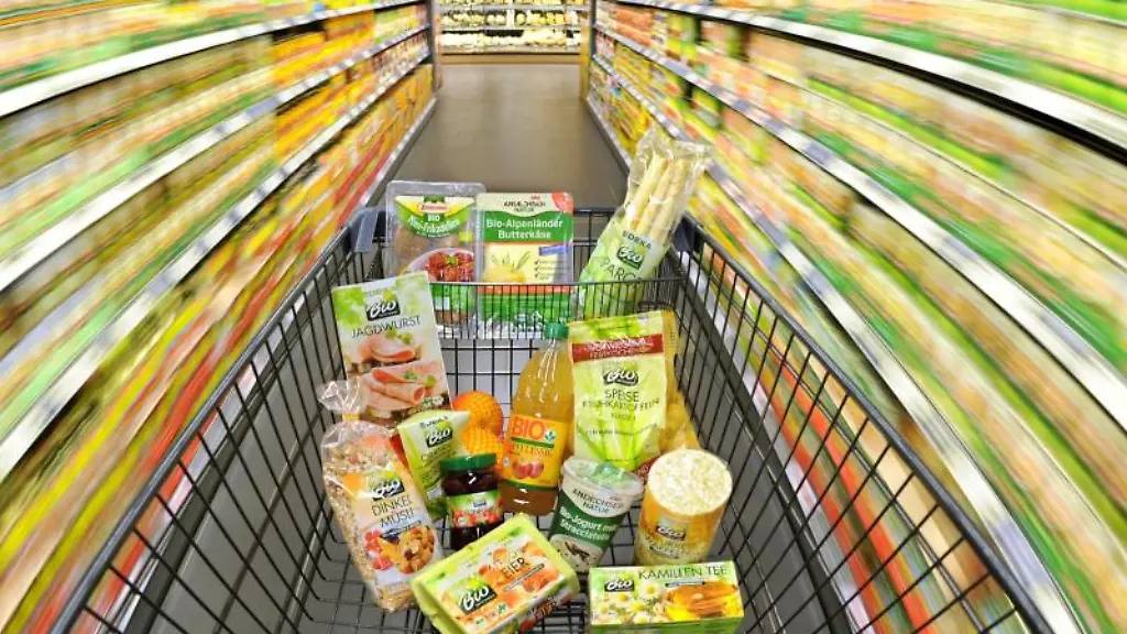 Ein-Einkaufswagen-mit-Lebensmitteln-wird-durch-einen-Supermarkt-geschoben