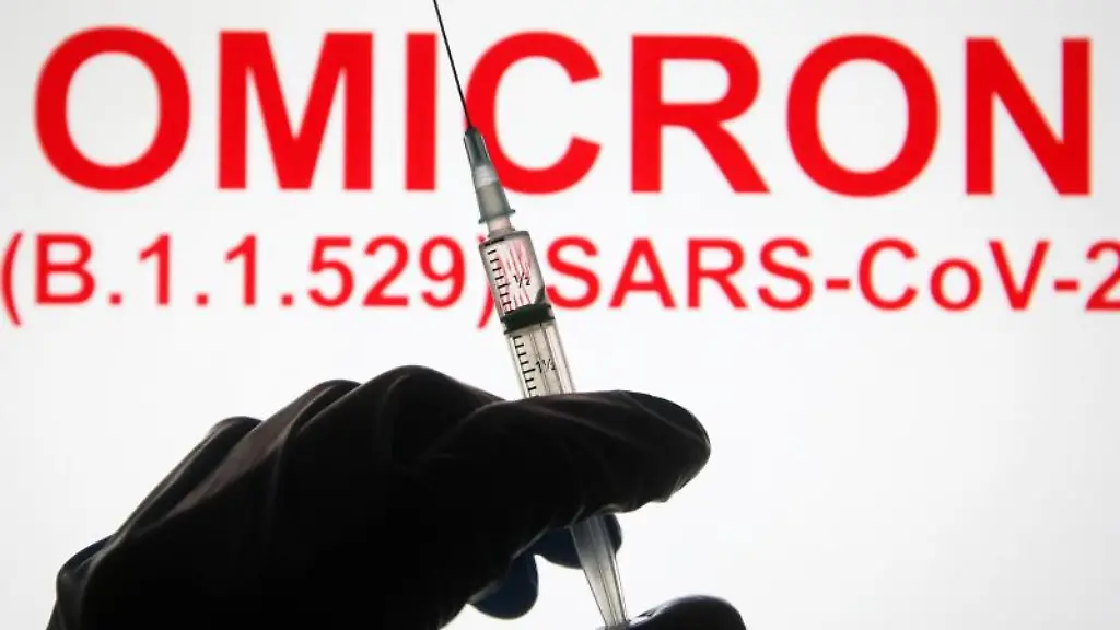Eine-Hand-haelt-vor-der-Aufschrift-Omicron-B-1-1-529-SARS-CoV-2-eine-Spritze-hoch