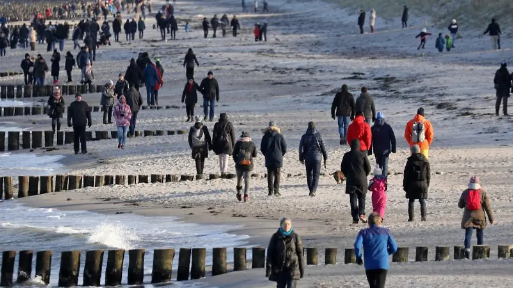 Viele-Spaziergaenger-sind-bei-Winterwetter-am-Ostseestrand-unterwegs