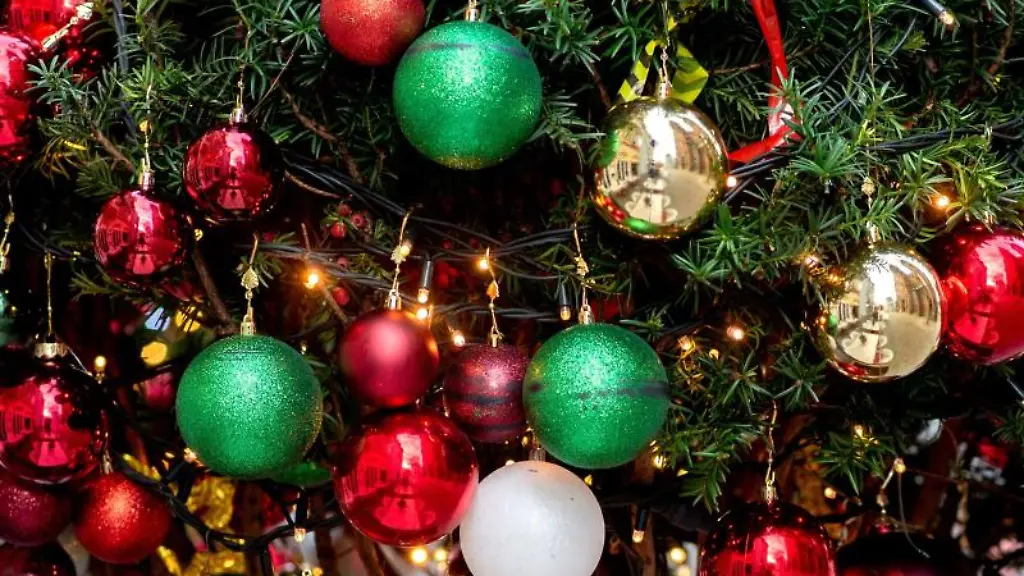 Ein-Weihnachtsbaum-ist-mit-zahlreichen-Christbaumkugeln-und-Lichterketten-geschmueckt