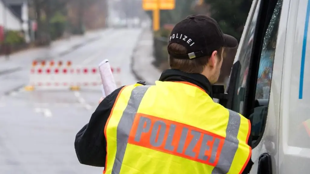 Ein-Polizist-steht-nahe-dem-Fundort-einer-Fliegerbombe-an-der-gesperrten-Hauptstrasse