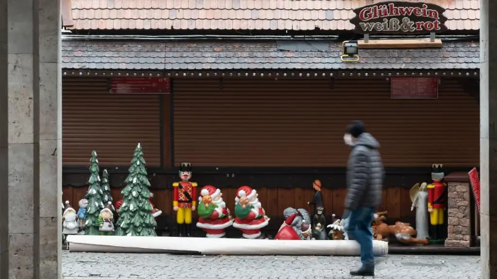 Ein-Mann-geht-an-einer-Weihnachtsmarktsbude-vorbei