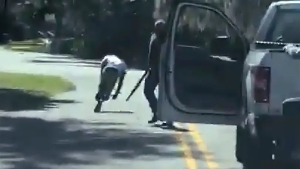 Eine-Videoaufnahme-zeigt-Ahmaud-Arbery-wie-er-nach-einem-Schuss-stolpert-und-zu-Boden-faellt-Neben-ihm-steht-der-Todesschuetze-Travis-McMichael-mit-einer-Waffe
