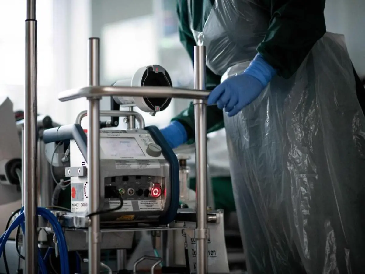 Eine-Pflegekraft-steht-auf-einer-Intensivstation-in-einem-Zimmer-und-bedient-eine-Herz-Lungen-Maschine