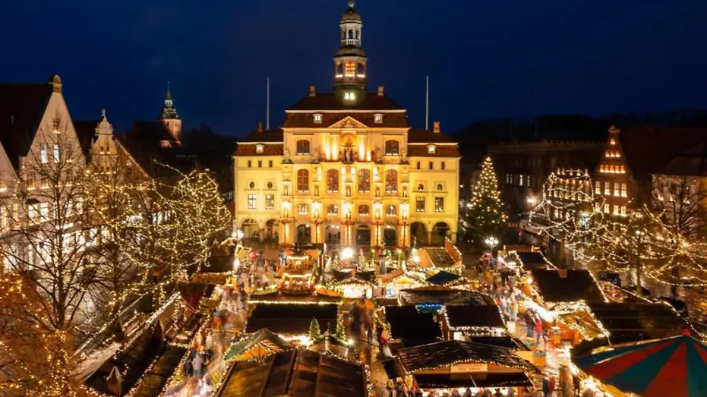 Besucher-gehen-in-Lueneburg-ueber-den-Weihnachtsmarkt-vor-dem-Rathaus-der-Stadt