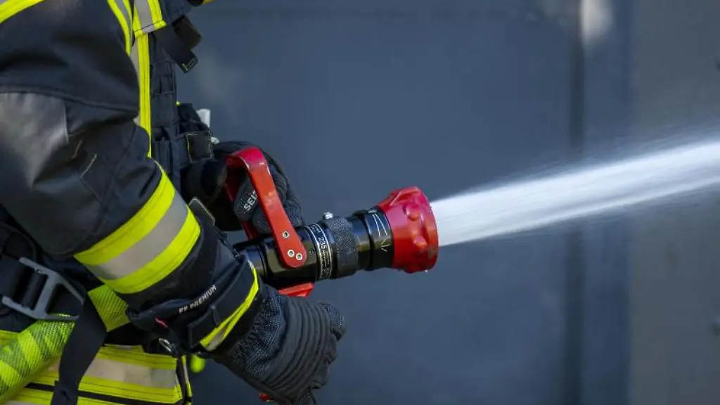 Ein-Mitglied-der-Feuerwehr-spritzt-aus-einem-Schlauch-mit-Wasser